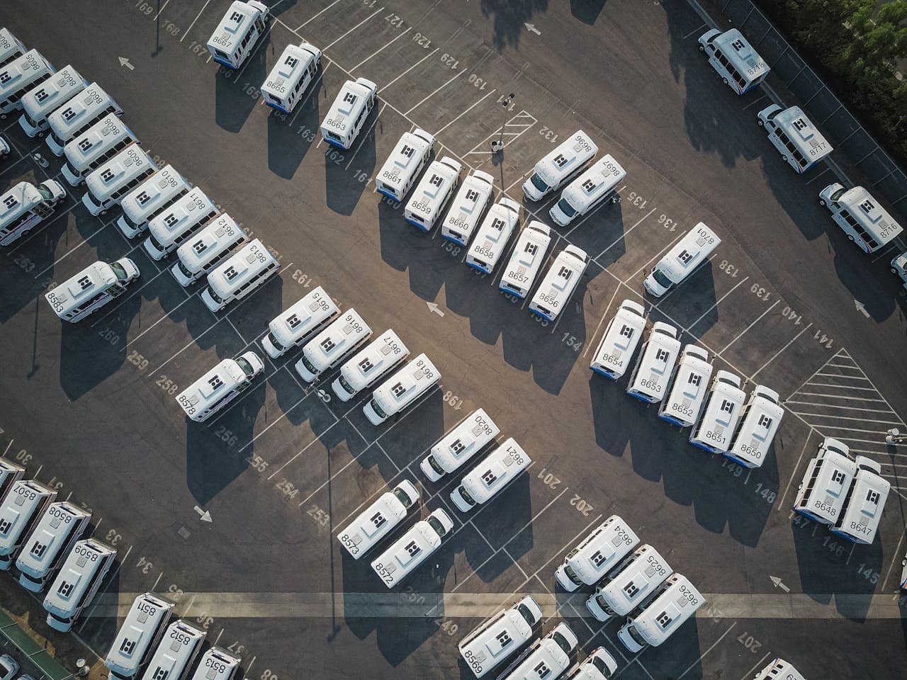 our-story Aerial drone shot of neatly organized vans in a large parking lot.